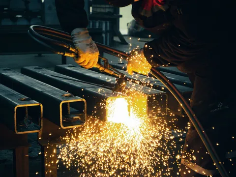 A cutting torch slicing through steel sections in a shower of sparks