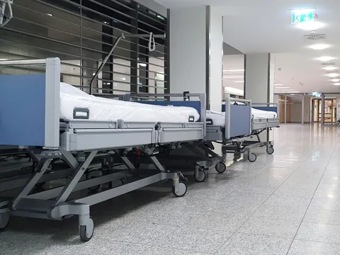 Hospital beds lined up along a bright corridor