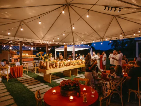 Guests dining under a lit marquee at night