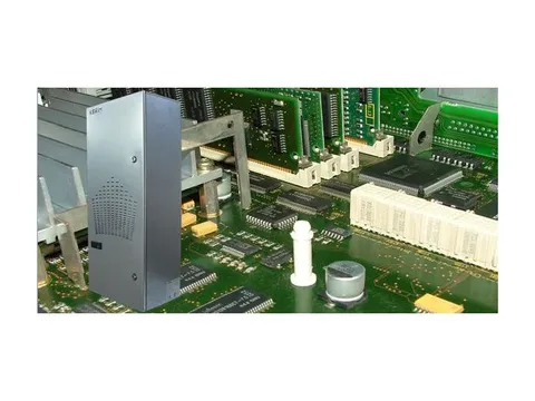 A slim silver panel air conditioner beside the circuit boards of a control system