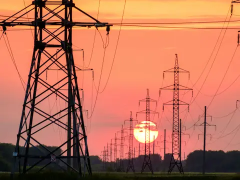 Electricity pylons and power lines at sunset